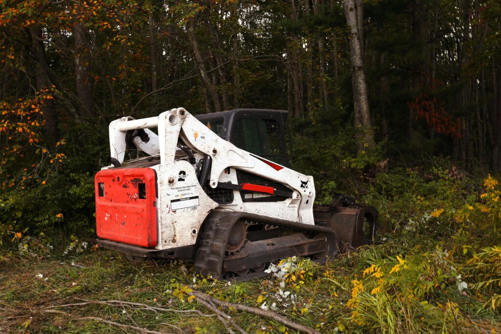 A bulldozer parked in a forest clearing surrounded by autumn foliage in Harbor Springs, Michigan.